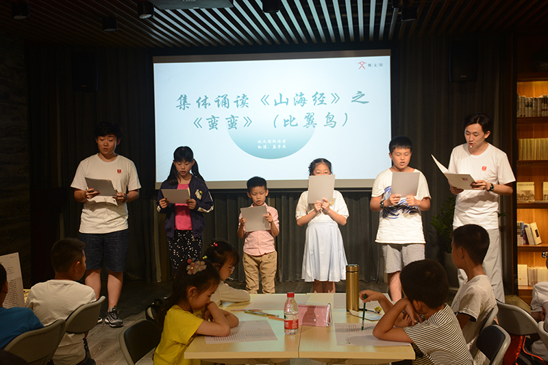 1528182627605715.jpg 大學(xué)生領(lǐng)讀者帶領(lǐng)小朋友們一起誦讀《山海經(jīng)》經(jīng)典篇目(鄧超穎 攝).JPG