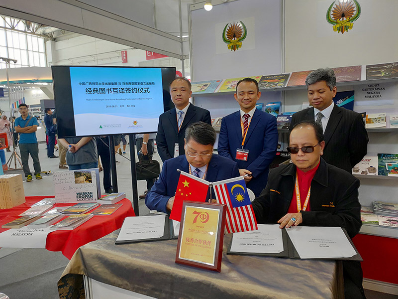 廣西師范大學(xué)出版社集團黨委書(shū)記、董事長(cháng)張藝兵（左前一）與馬來(lái)西亞國家語(yǔ)文出版局理事長(cháng)Datuk Abang Sallehuddin Abang Shokeran簽訂合約（陳子鋒攝）.jpg