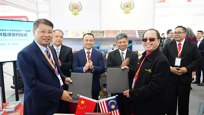 廣西師范大學(xué)出版社集團黨委書(shū)記、董事長(cháng)張藝兵（左前一）與馬來(lái)西亞國家語(yǔ)文出版局理事長(cháng)Datuk Abang Sallehuddin Abang Shokeran交換簽約文件（陳子鋒攝）.jpg