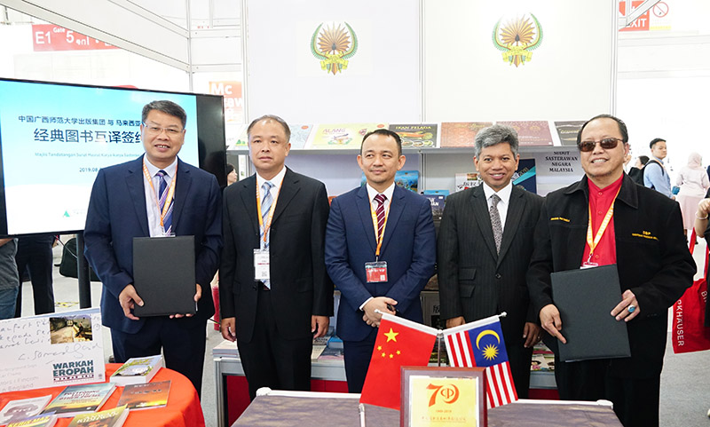 簽約儀式合影（左起：廣西師大出版社集團黨委書(shū)記、董事長(cháng)張藝兵，廣西師范大學(xué)黨委副書(shū)記趙鐵，馬來(lái)西亞教育部部長(cháng)Dr. Maszlee Malik，馬來(lái)西亞駐華大使RajaDato’ Nushirwan Zainal Abidin，馬來(lái)西亞國家語(yǔ)文出版局理事長(cháng)Datuk Abang Sallehuddin Abang Shokeran）.jpg